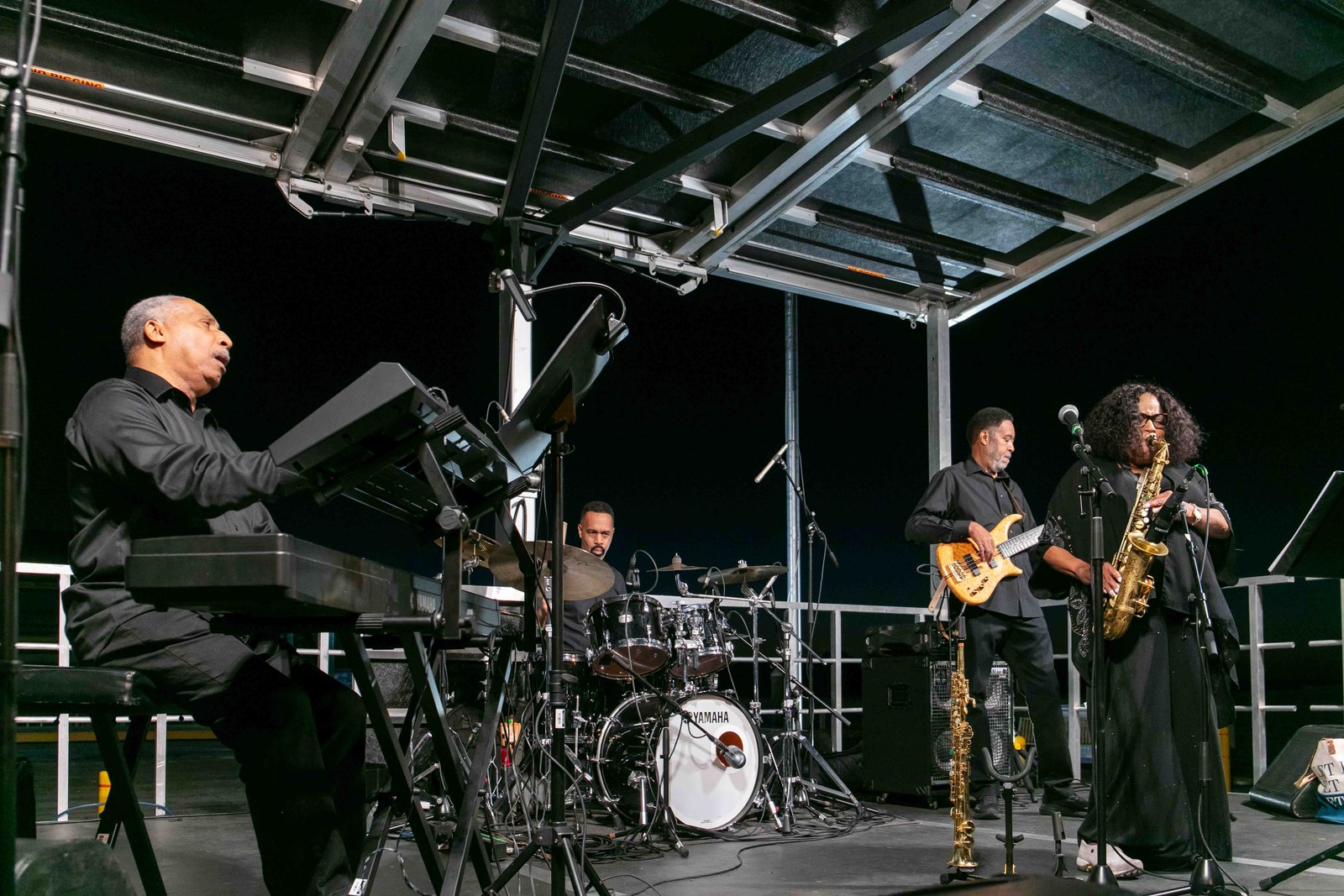 Drummer and saxophonist on the nighttime stage