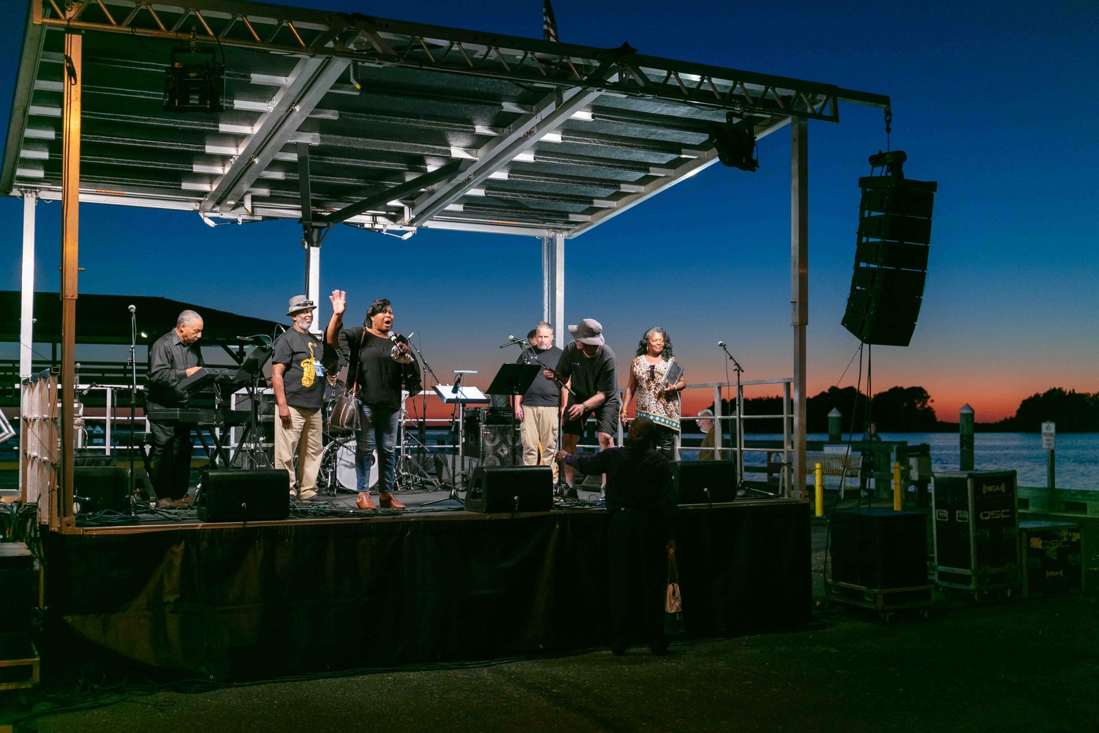 Band performing beneath the deep blue evening sky